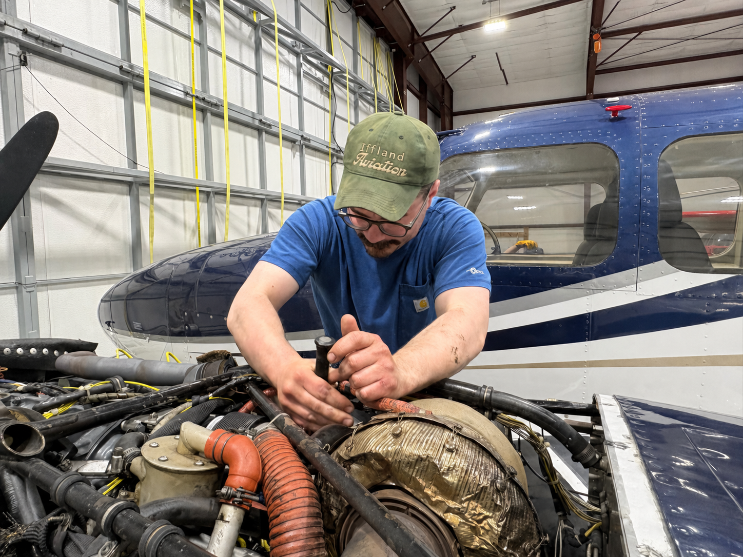 Michael Iffland working on a piston aircraft engine in the shop.